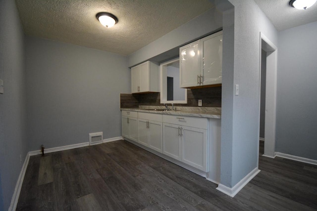 4646 N 51st Blvd, Milwaukee, WI 53218 - kitchen featuring a textured ceiling, dark wood finished floors, white cabinets, light countertops, and backsplash