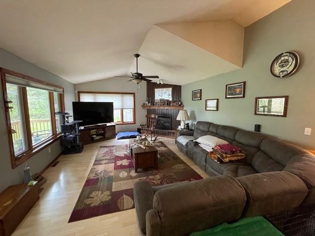 13550 W Froemel Rd, Hayward, WI 54843 - living area featuring ceiling fan, lofted ceiling, light wood-style flooring, and a fireplace with raised hearth
