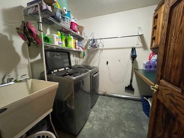 13550 W Froemel Rd, Hayward, WI 54843 - laundry area featuring washing machine and dryer, a sink, and a textured ceiling