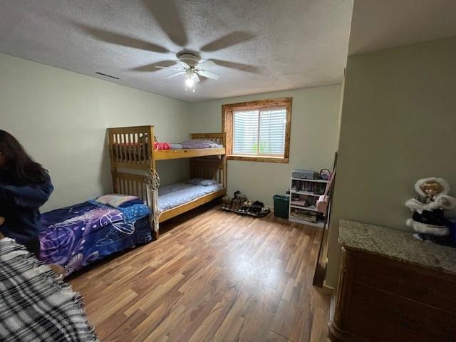 13550 W Froemel Rd, Hayward, WI 54843 - bedroom featuring wood finished floors, a textured ceiling, and ceiling fan