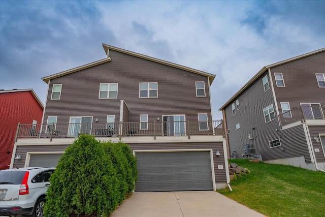 9327 Silicon Prairie Pkwy, Verona, WI 53593 - rear view of house featuring an attached garage, concrete driveway, a yard, and a balcony