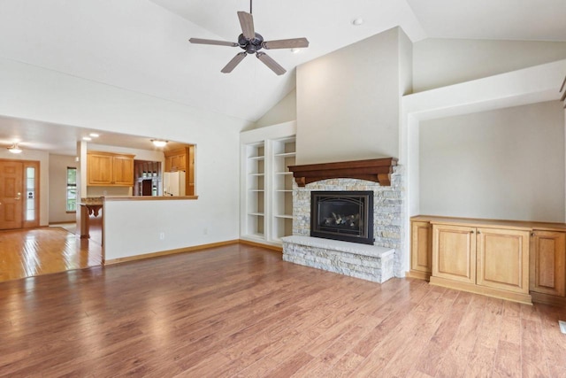 1408 Groves Ln Unit 12, Union Grove, WI 53182 - unfurnished living room featuring light wood-style flooring, high vaulted ceiling, a fireplace, built in features, and ceiling fan