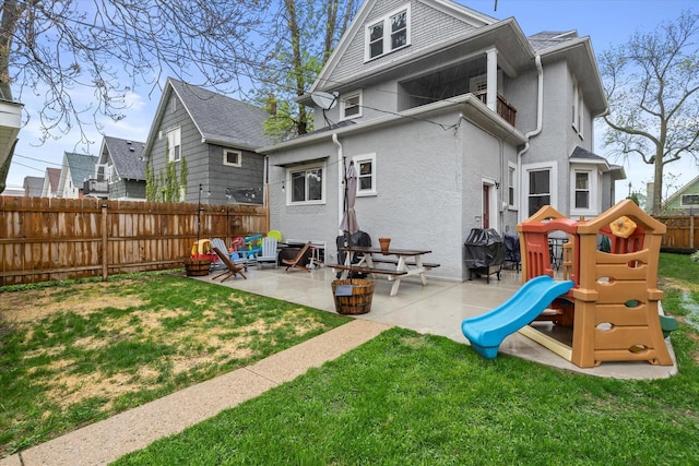 2207 N 51st St, Milwaukee, WI 53208 - back of house with a playground, a patio area, and stucco siding