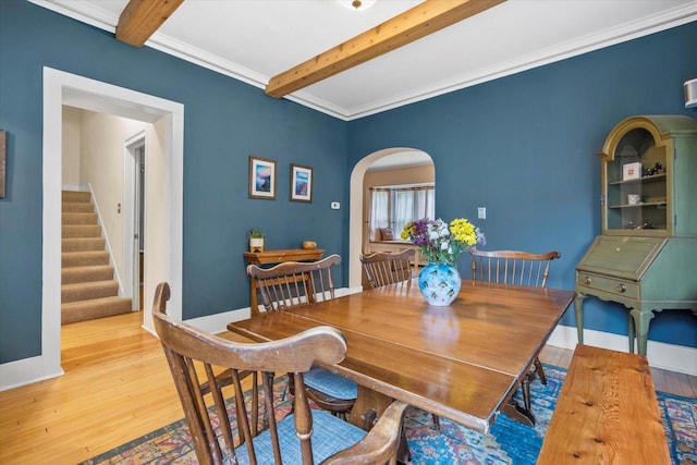 2207 N 51st St, Milwaukee, WI 53208 - dining space featuring arched walkways, beamed ceiling, wood finished floors, stairway, and baseboards