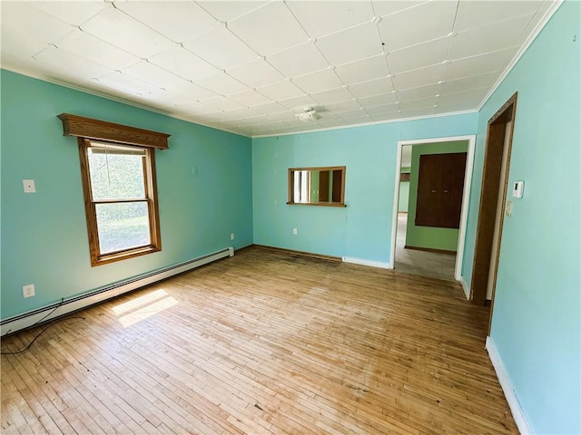 N4719 Schmidt Rd, Ladysmith, WI 54848 - spare room with baseboard heating, hardwood / wood-style flooring, baseboards, and ornamental molding