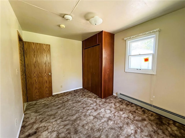 N4719 Schmidt Rd, Ladysmith, WI 54848 - unfurnished bedroom featuring a baseboard heating unit, a closet, carpet, and baseboards