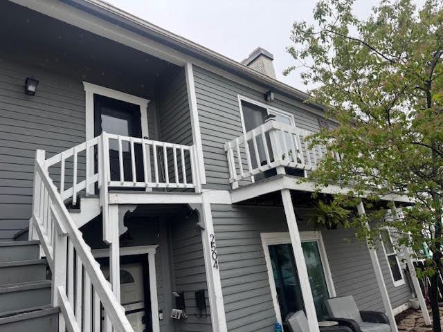 2504 S Delaware Ave Unit 102, Milwaukee, WI 53207 - view of side of home with a balcony, stairs, and a chimney