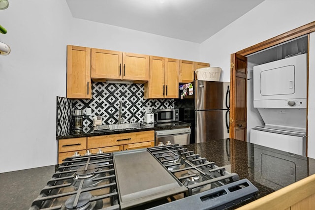 2504 S Delaware Ave Unit 102, Milwaukee, WI 53207 - kitchen with estacked washer and dryer, stainless steel appliances, decorative backsplash, and a sink