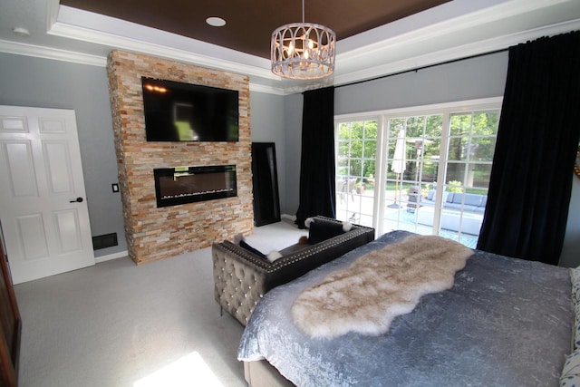 6606 Fieldstone Ct, Racine, WI 53402 - carpeted bedroom featuring a raised ceiling, access to exterior, crown molding, a chandelier, and a fireplace