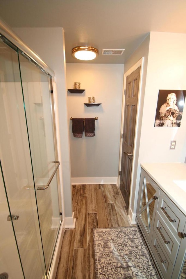 6606 Fieldstone Ct, Racine, WI 53402 - bathroom with wood finished floors, a shower stall, baseboards, and vanity