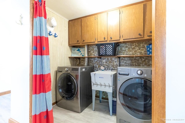 2894 Waubesa Ave, Madison, WI 53711 - laundry area featuring separate washer and dryer, cabinet space, and light wood-style flooring