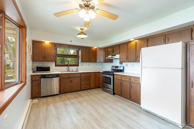 2894 Waubesa Ave, Madison, WI 53711 - kitchen with stainless steel appliances, a sink, under cabinet range hood, light wood-style flooring, and light countertops