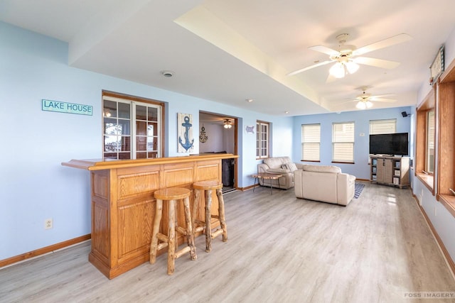 2894 Waubesa Ave, Madison, WI 53711 - living room featuring a dry bar, light wood finished floors, a ceiling fan, and baseboards