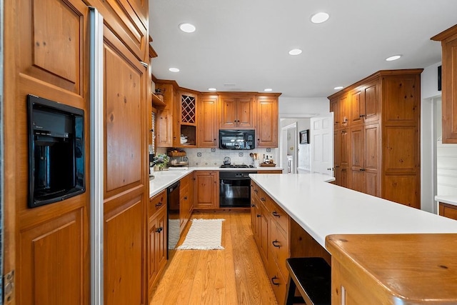 2522 Martha Ave, Green Bay, WI 54301 - kitchen featuring black appliances, light wood-type flooring, open shelves, brown cabinetry, and recessed lighting