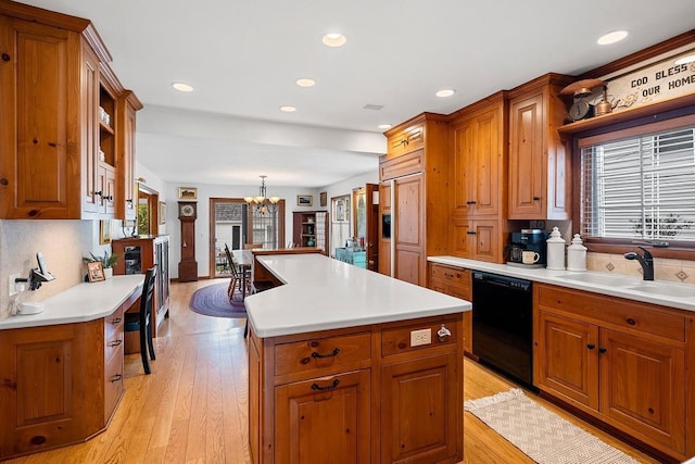 2522 Martha Ave, Green Bay, WI 54301 - kitchen with black dishwasher, brown cabinetry, a kitchen island, a chandelier, and a sink