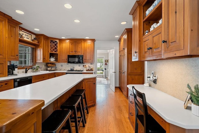 2522 Martha Ave, Green Bay, WI 54301 - kitchen with open shelves, black appliances, recessed lighting, light wood-style flooring, and brown cabinets