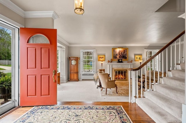 2522 Martha Ave, Green Bay, WI 54301 - entryway featuring crown molding, a glass covered fireplace, healthy amount of natural light, stairway, and wood finished floors