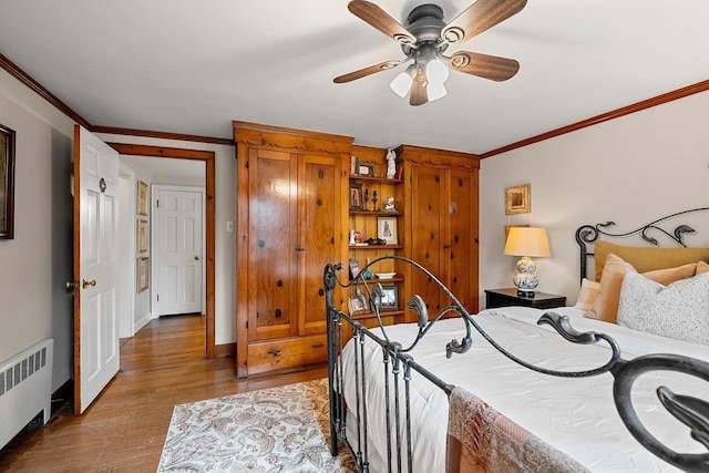 2522 Martha Ave, Green Bay, WI 54301 - bedroom with radiator heating unit, wood finished floors, crown molding, baseboards, and ceiling fan