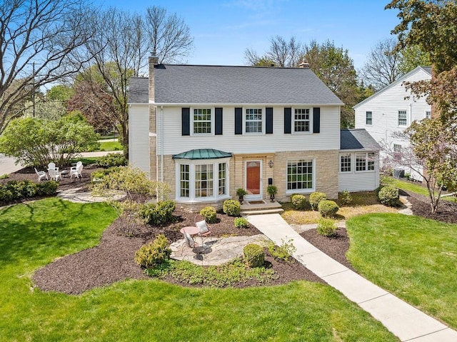 2522 Martha Ave, Green Bay, WI 54301 - view of front of home with a chimney, a front lawn, stone siding, and a shingled roof