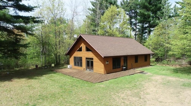 7431 Jordan Buck Trl, Danbury, WI 54830 - rear view of house featuring a deck, a yard, a shingled roof, and a forest view