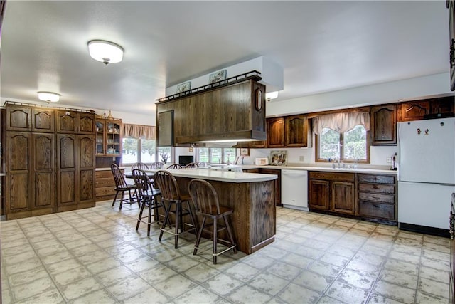 12482 65th Ave, Chippewa Falls, WI 54729 - kitchen featuring white appliances, light floors, a kitchen breakfast bar, and healthy amount of natural light