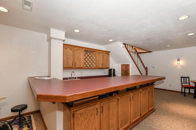 884 Joshua Ct, Pewaukee, WI 53072 - kitchen with light carpet, recessed lighting, a peninsula, baseboards, and brown cabinets