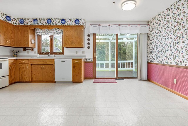 2009 N Eugene St, Appleton, WI 54914 - kitchen with wallpapered walls, white appliances, light countertops, brown cabinets, and wainscoting