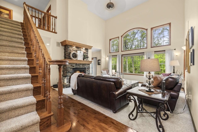 4700 Beaver Dam Rd, Stevens Point, WI 54482 - living room featuring a towering ceiling, stairway, a fireplace, and wood finished floors