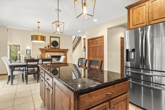4700 Beaver Dam Rd, Stevens Point, WI 54482 - kitchen featuring stainless steel refrigerator with ice dispenser, a glass covered fireplace, light tile patterned floors, dark stone counters, and recessed lighting
