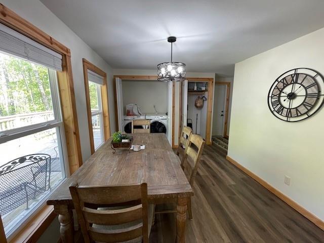 12757 County Highway T, Hayward, WI 54843 - dining area with a chandelier, washing machine and dryer, dark wood finished floors, and baseboards