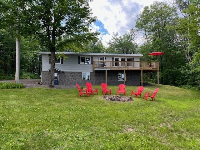 12757 County Highway T, Hayward, WI 54843 - back of property with a wooden deck, an outdoor fire pit, and a lawn