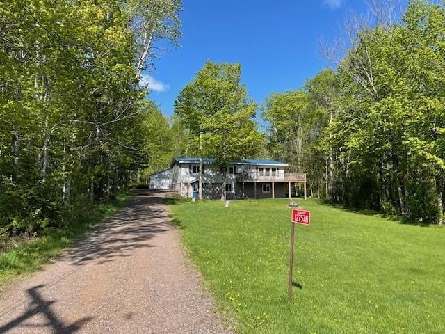 12757 County Highway T, Hayward, WI 54843 - view of front facade featuring a front yard, driveway, a wooden deck, and a wooded view