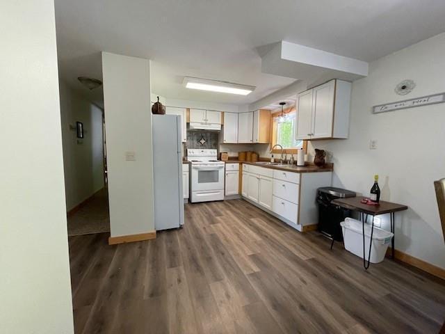 12757 County Highway T, Hayward, WI 54843 - kitchen with white appliances, a sink, under cabinet range hood, dark wood-style flooring, and white cabinetry
