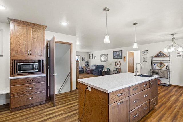 1306 Nelson St, Green Bay, WI 54304 - kitchen featuring stainless steel microwave, dark wood-style flooring, a sink, light countertops, and decorative light fixtures