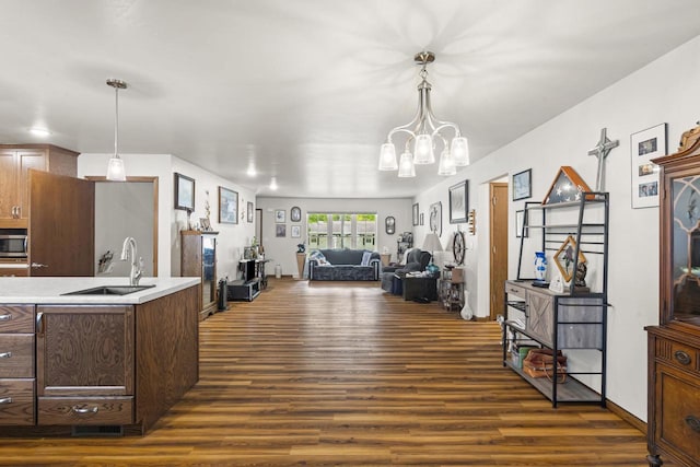 1306 Nelson St, Green Bay, WI 54304 - kitchen featuring stainless steel microwave, a sink, dark wood-style flooring, light countertops, and a chandelier