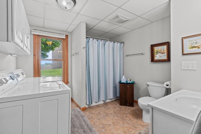 W13491 Reeds Corners Rd, Ripon, WI 54971 - bathroom featuring washing machine and clothes dryer, vanity, toilet, a shower with curtain, and a paneled ceiling
