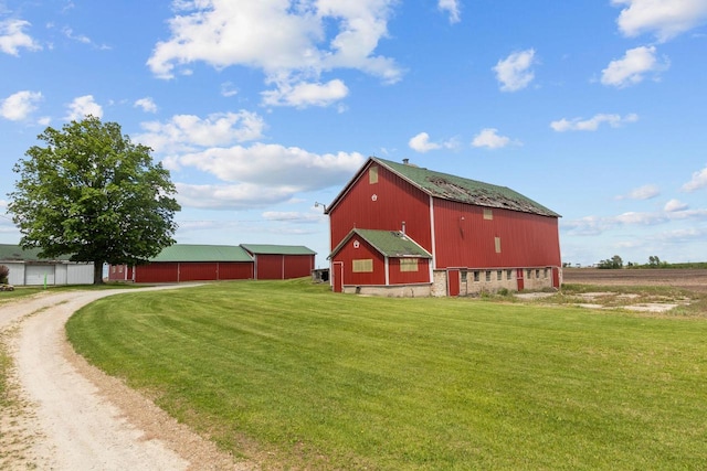 W13491 Reeds Corners Rd, Ripon, WI 54971 - view of side of home featuring driveway, a lawn, an outdoor structure, a detached garage, and a pole building