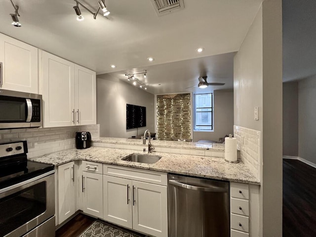 234 N Broadway Unit 302, Milwaukee, WI 53202 - kitchen with appliances with stainless steel finishes, a sink, track lighting, tasteful backsplash, and white cabinetry