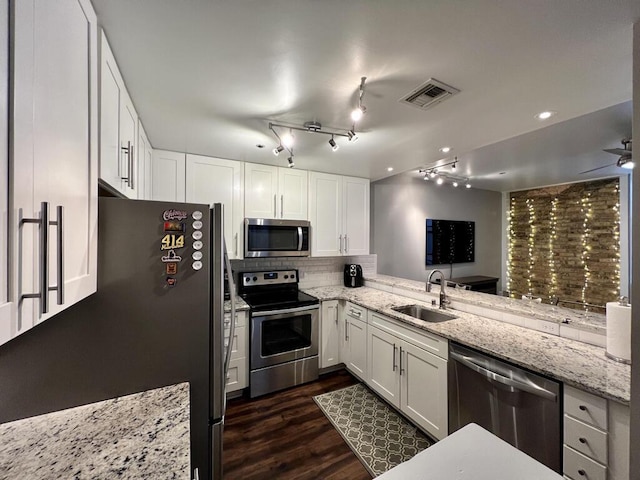 234 N Broadway Unit 302, Milwaukee, WI 53202 - kitchen with appliances with stainless steel finishes, a sink, white cabinets, and light stone countertops
