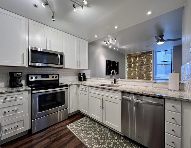 234 N Broadway Unit 302, Milwaukee, WI 53202 - kitchen featuring appliances with stainless steel finishes, rail lighting, a sink, backsplash, and white cabinetry