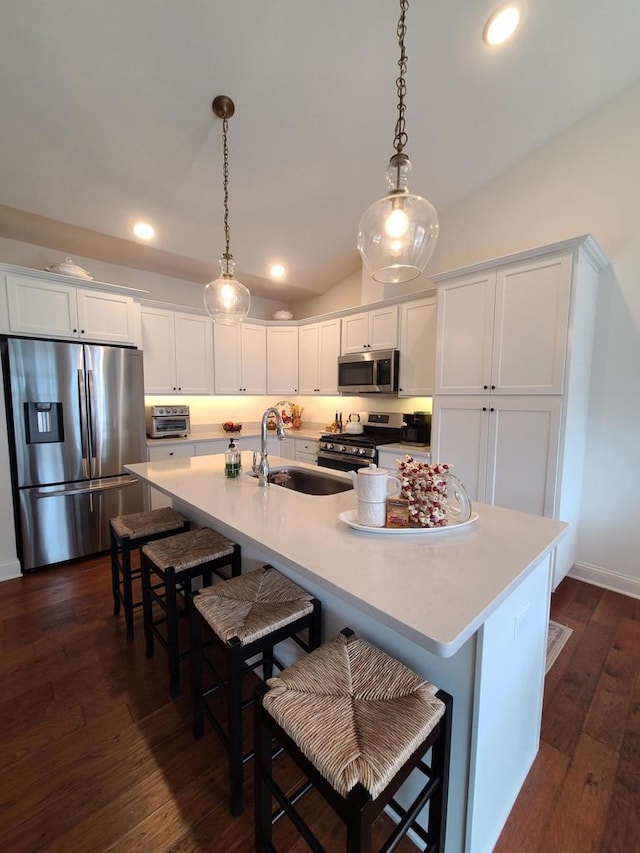 609 Cadence Cir, Lake Geneva, WI 53147 - kitchen featuring appliances with stainless steel finishes, white cabinetry, a sink, vaulted ceiling, and dark wood-type flooring
