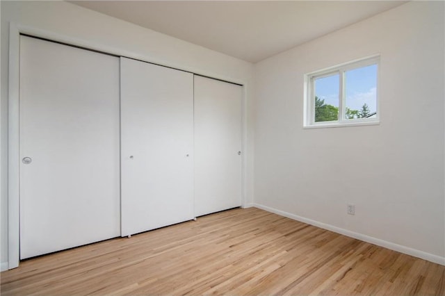 619 Aspen Ave, Amery, WI 54001 - unfurnished bedroom with light wood finished floors, a closet, and baseboards
