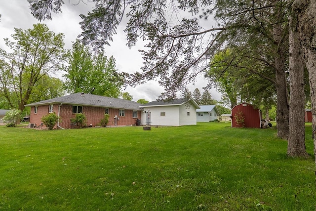 205 W Hickory St, Abbotsford, WI 54405 - rear view of property featuring a lawn and brick siding