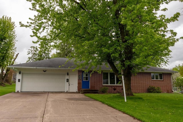 205 W Hickory St, Abbotsford, WI 54405 - ranch-style house with concrete driveway, a garage, a front lawn, and brick siding