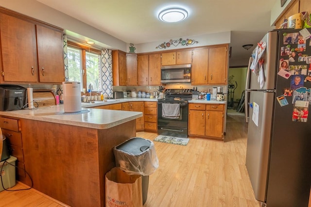 205 W Hickory St, Abbotsford, WI 54405 - kitchen with appliances with stainless steel finishes, light countertops, light wood-style floors, and brown cabinets