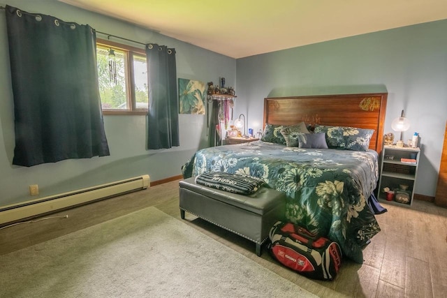 205 W Hickory St, Abbotsford, WI 54405 - bedroom with a baseboard heating unit, hardwood / wood-style flooring, and baseboards