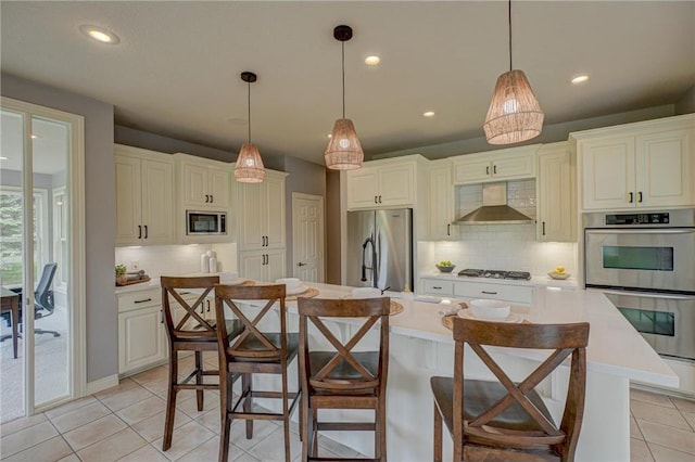 278 Saint Annes Pkwy, Hudson, WI 54016 - kitchen with wall chimney range hood, stainless steel appliances, light tile patterned flooring, decorative backsplash, and light countertops