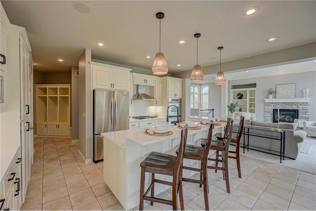 278 Saint Annes Pkwy, Hudson, WI 54016 - kitchen with stainless steel fridge, wall chimney range hood, recessed lighting, light tile patterned floors, and light countertops