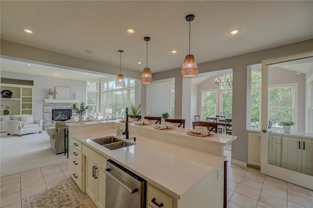 278 Saint Annes Pkwy, Hudson, WI 54016 - kitchen featuring dishwasher, open floor plan, light tile patterned flooring, a sink, and light countertops