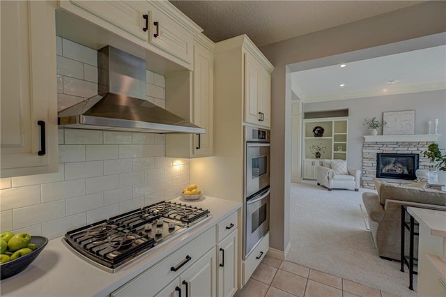 278 Saint Annes Pkwy, Hudson, WI 54016 - kitchen featuring wall chimney range hood, appliances with stainless steel finishes, light countertops, light tile patterned flooring, and light colored carpet